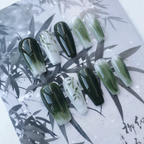 Set of green and black gradient nail art on a leaf-patterned background