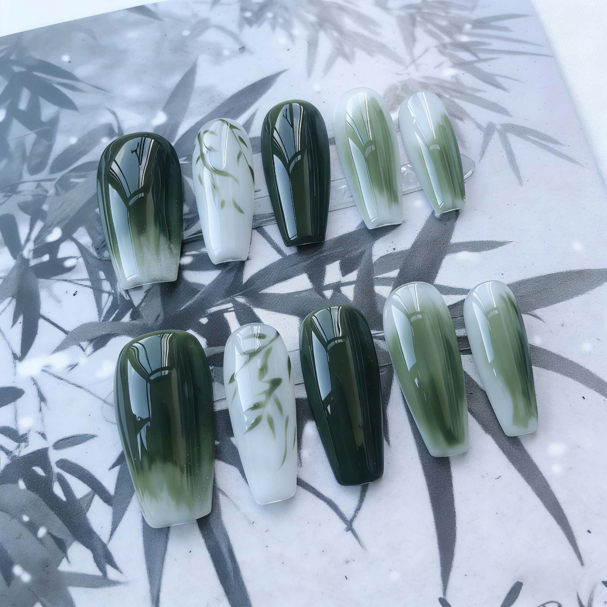 Set of green and white gradient nail designs on a leaf-patterned background