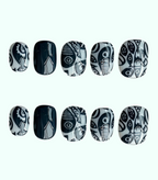 Black and white patterned nail art designs on a white background
