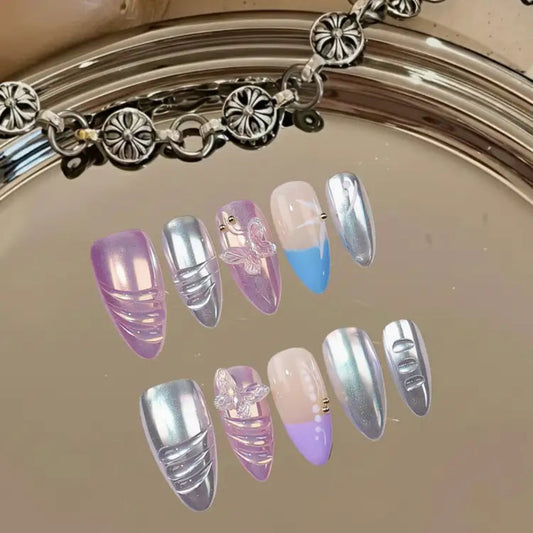 Set of decorative nails with pastel and metallic colors on a reflective surface.