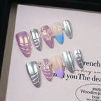 Set of multicolored nail art designs on a textured surface with text.