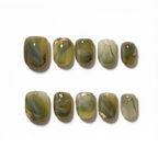 Set of green marbled nail art designs on a white background