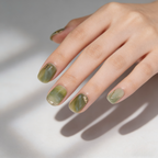Hand with green nail polish on a neutral background