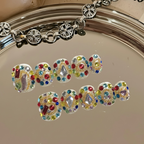 Bracelet with colorful gemstones spelling 'LOVE' on a reflective surface.