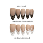 Handmade press-on nails with lace design in medium almond color by ABLE Nail on a white background.