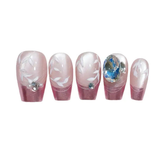 Set of five decorative false nails with floral designs and gemstones on a white background