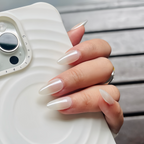 Hand with long, manicured nails holding a white phone case.