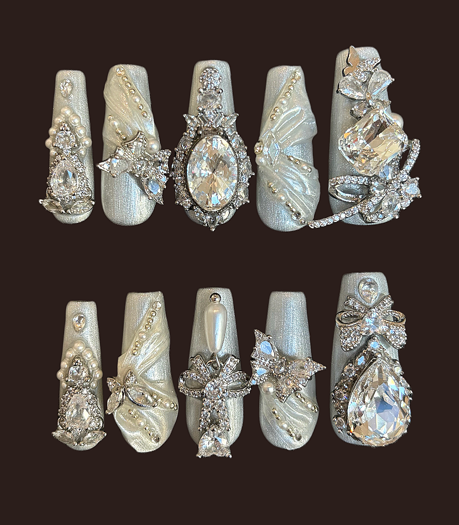 Decorative nail art with gemstones and butterflies on a dark background