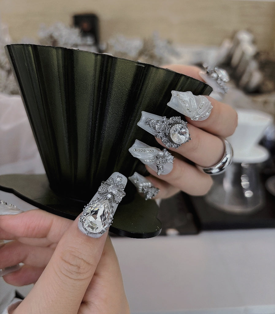Close-up of a hand with intricately designed silver rings on a blurred background