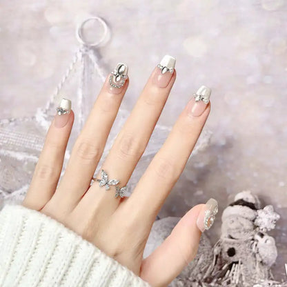 Hand with decorative nail art and rings against a blurred background