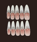 Set of decorative false nails with rhinestone accents on a dark background