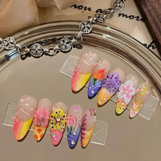Colorful nail art designs on a clear stand with a bracelet in the background.