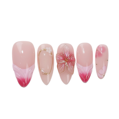 Set of pink and red gradient nails with gold accents on a white background