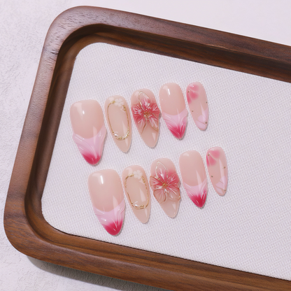 Set of pink and red gradient nail art designs on a wooden tray with a white cloth background