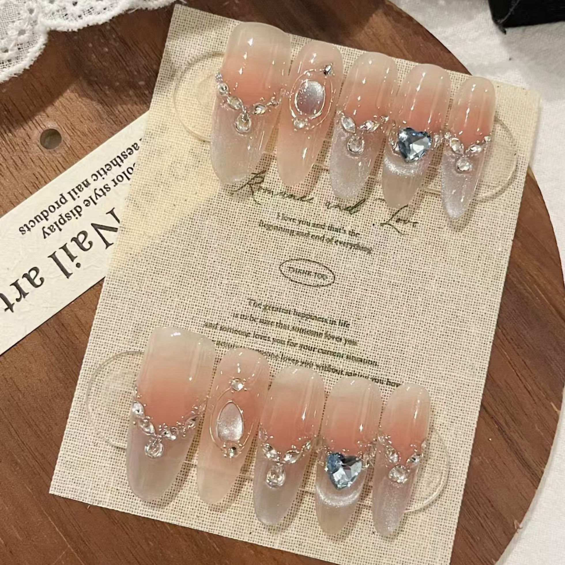Set of decorative false nails with rhinestones on a branded card.