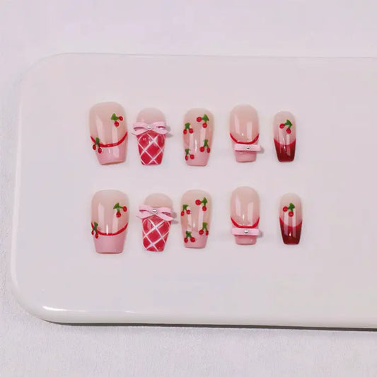 Set of nail art designs with cherry and bow decorations on a white background
