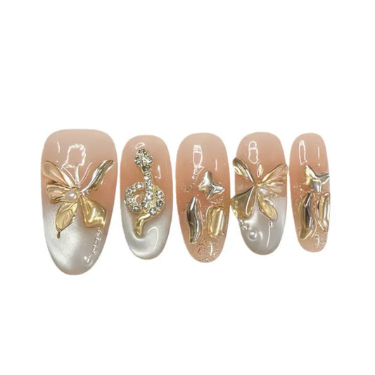 Set of five decorative nails with gold and silver designs on a white background