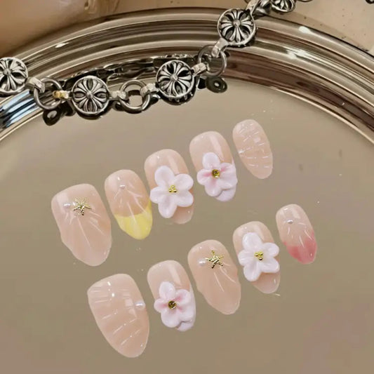 Decorative nail art with flowers and a bracelet on a reflective surface
