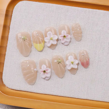 Decorative nail art with flowers and gold accents on a textured surface