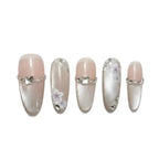 Set of decorative false nails with silver accents and floral designs on a white background