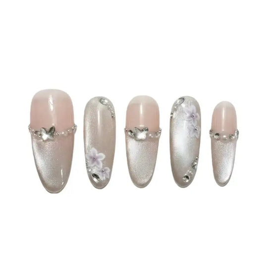 Set of decorative false nails with silver accents and floral designs on a white background