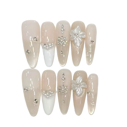 Set of decorative nails with flowers and rhinestones on a white background