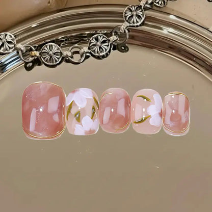 Nail art with floral design on a metallic surface