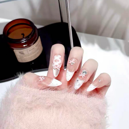 Close-up of a hand with decorative nails in front of a candle and mirror.
