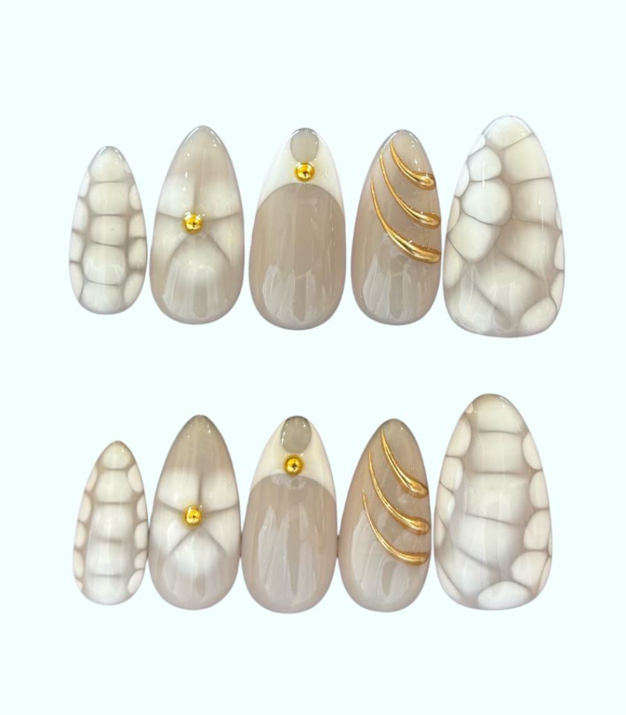 Set of marbled nail art designs with gold accents on a white background
