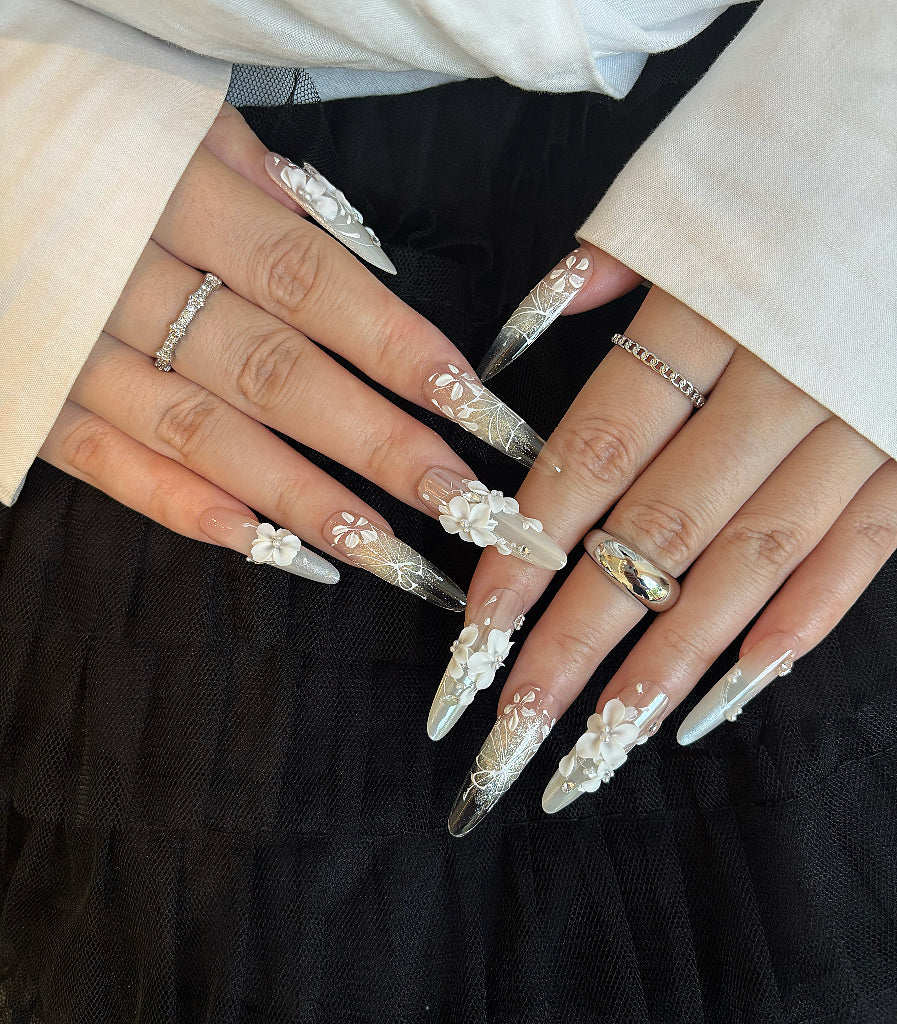 Close-up of hands with decorative nails and rings on a black background