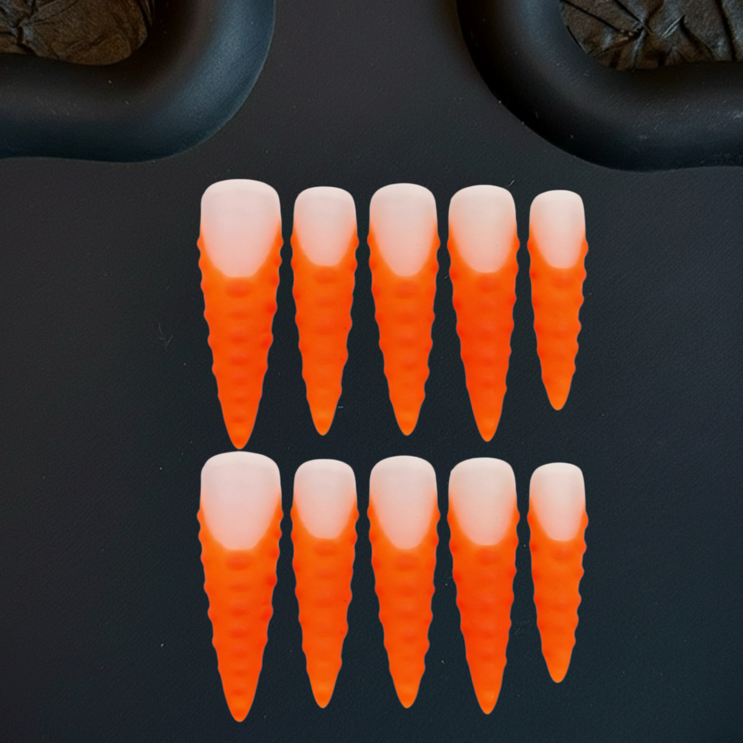 Orange and white carrot-shaped objects on a black background