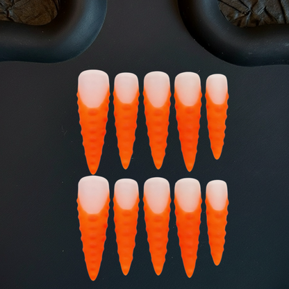 Orange and white carrot-shaped objects on a black background
