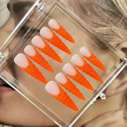 Set of false eyelashes with orange and beige gradient in a clear case.