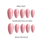 Set of pink short almond-shaped press-on nails by ABLE Nail on a white background.