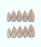Set of beige nail extensions with white polka dots on a white background