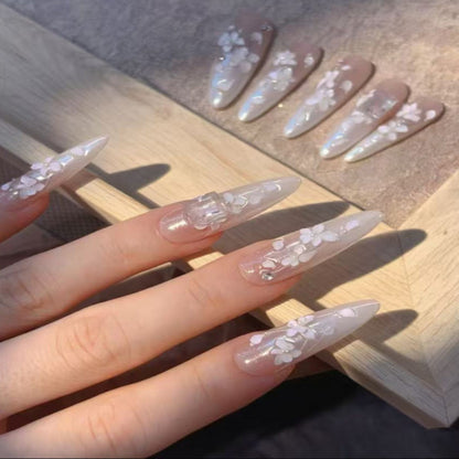 Almond-shaped nails with floral designs on a wooden surface