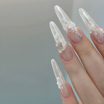 Nails with floral designs and a clear or transparent finish on a neutral background