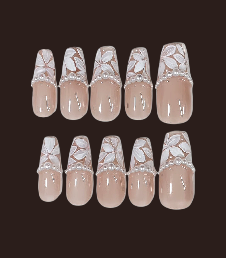Set of beige nail art designs with floral patterns on a dark background