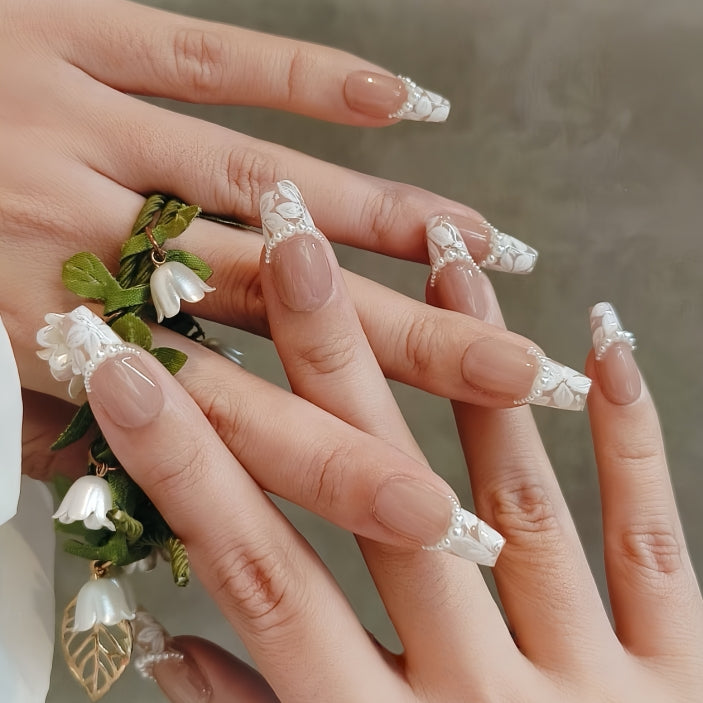 Close-up of hands with decorative nail art holding a small bouquet.