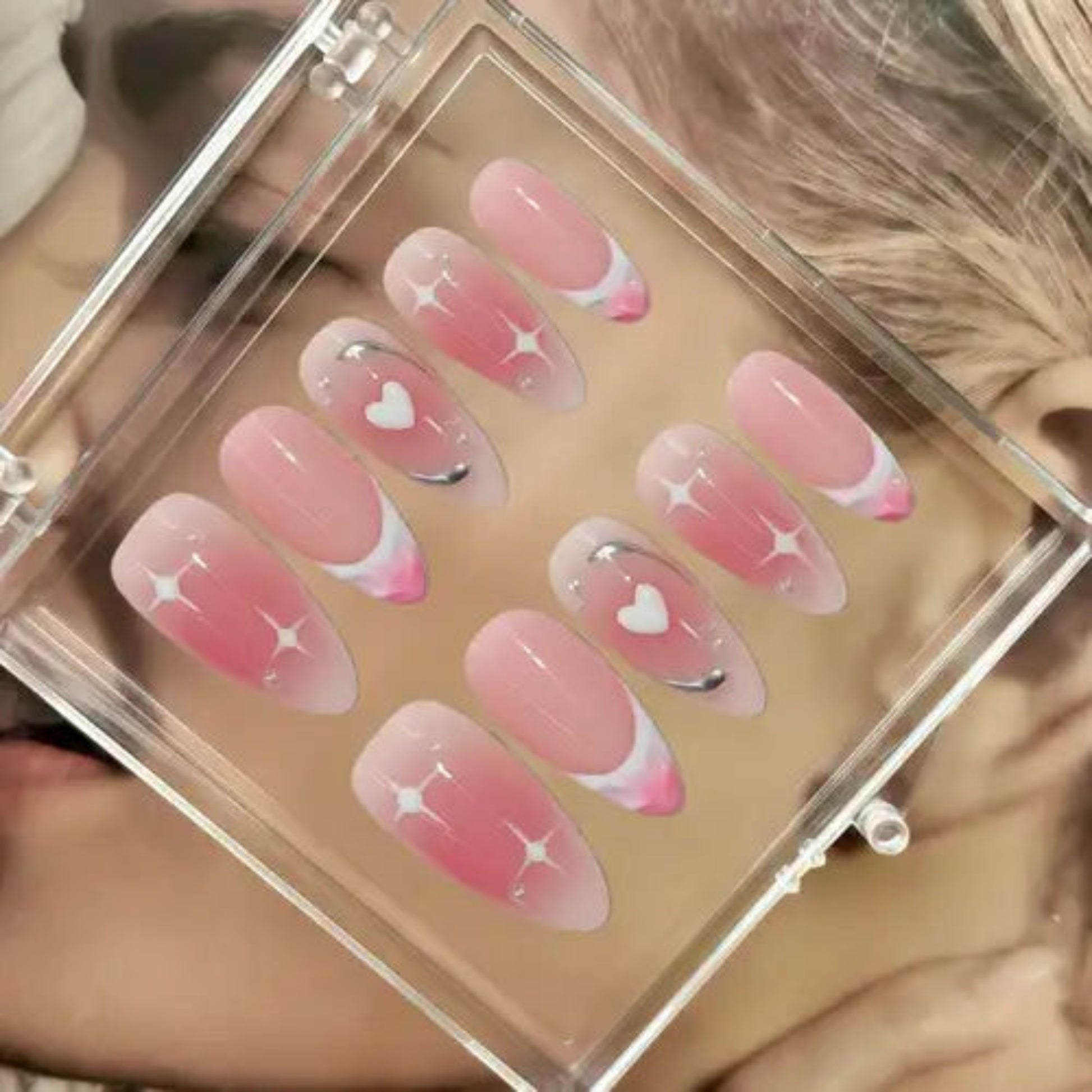 Set of pink and clear nail designs in a clear case