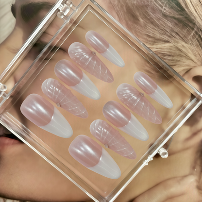 Set of false nails in a clear case held by a person with blonde hair.