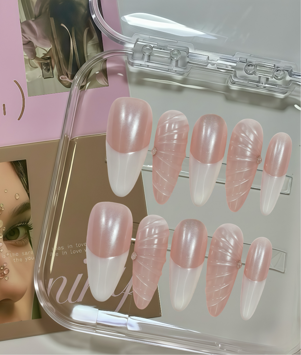 Set of pink and white false nails in a clear case with a magazine in the background.