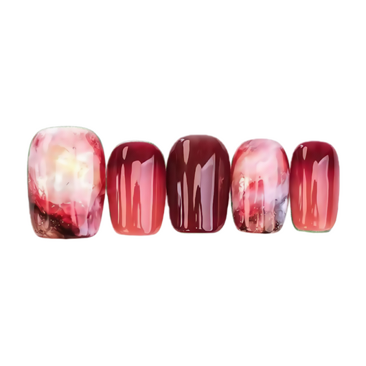 Set of five nail polish samples with red and pink gradient on a white background