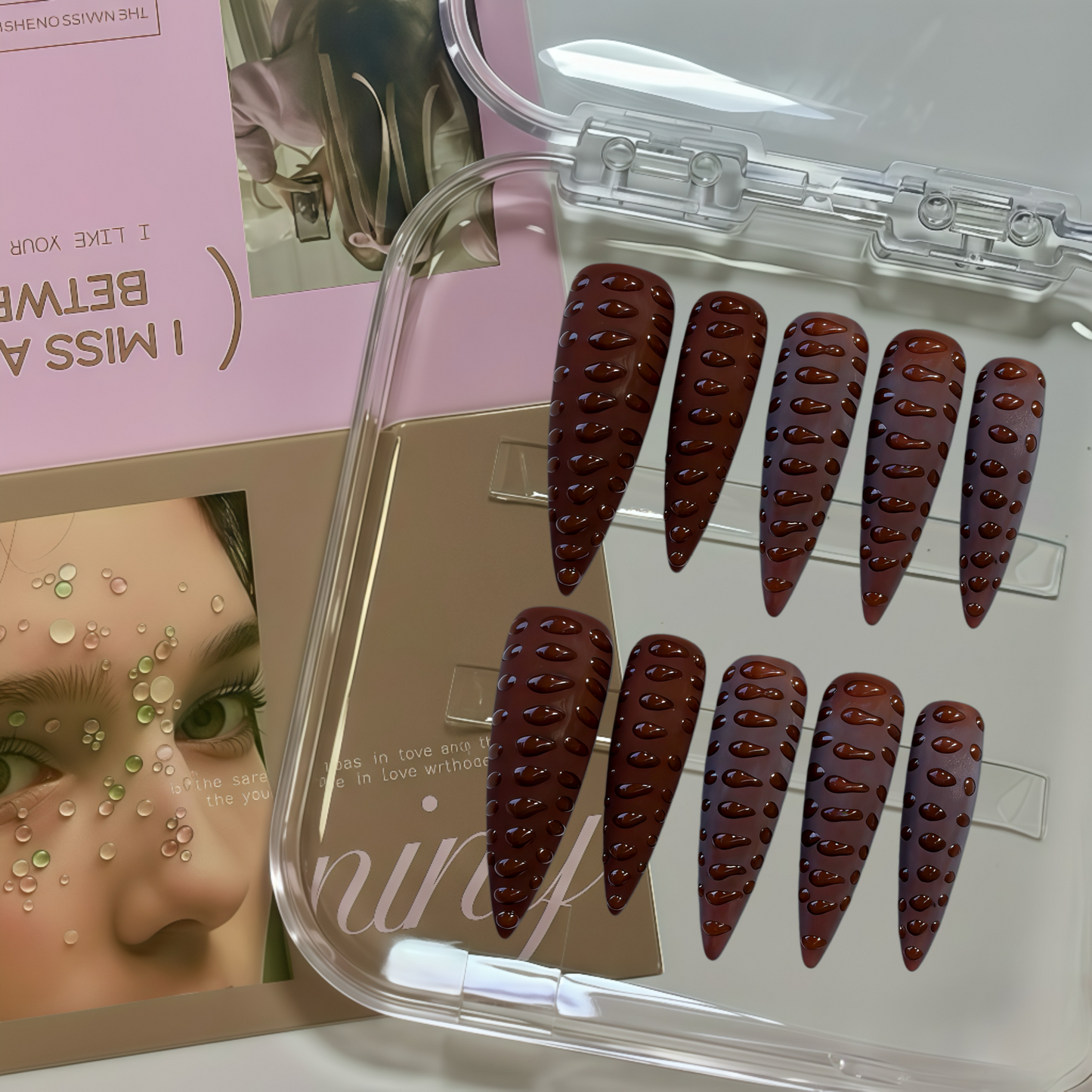 Set of false nails in a clear case with a magazine in the background