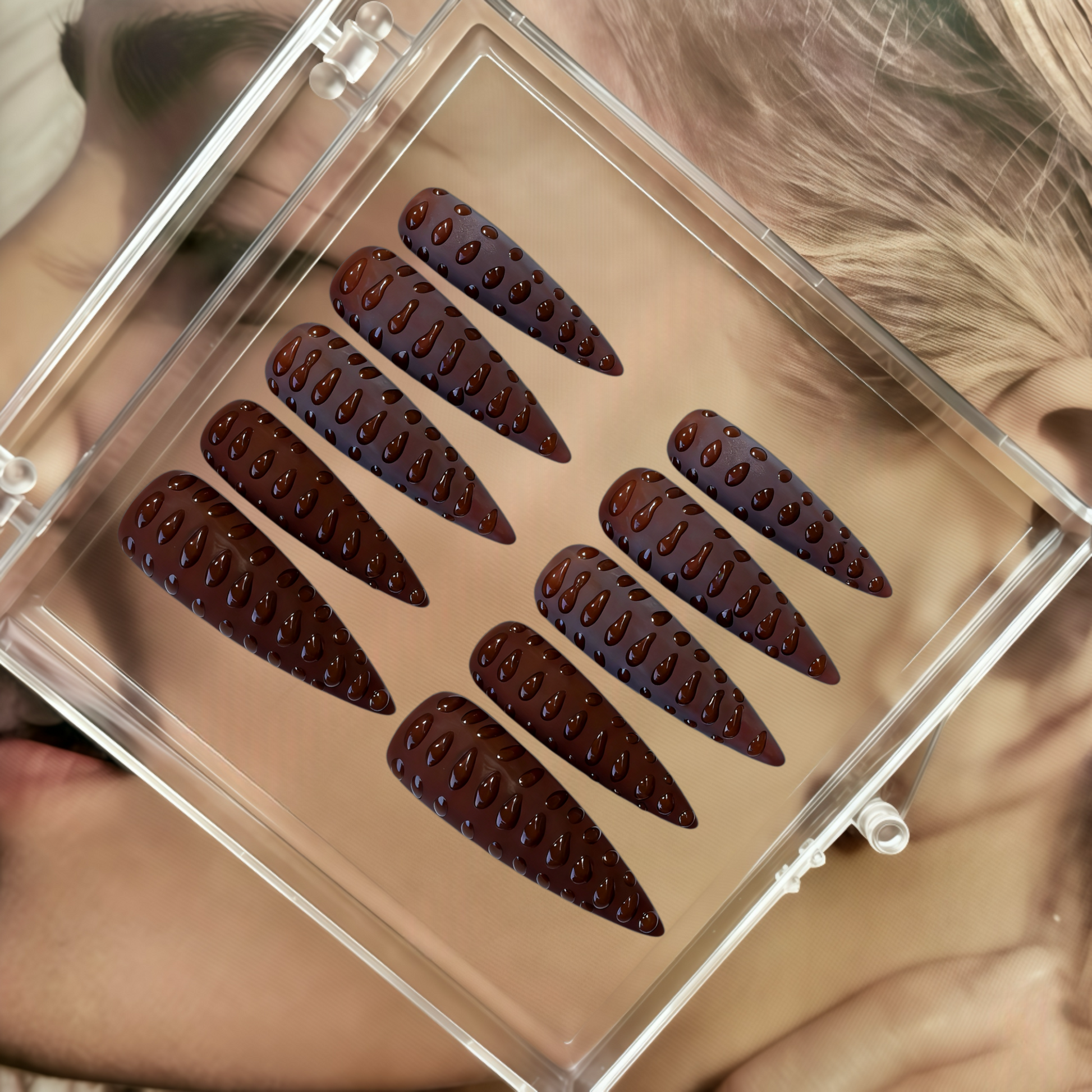 Set of false eyelashes in a clear case held by a person with blonde hair.