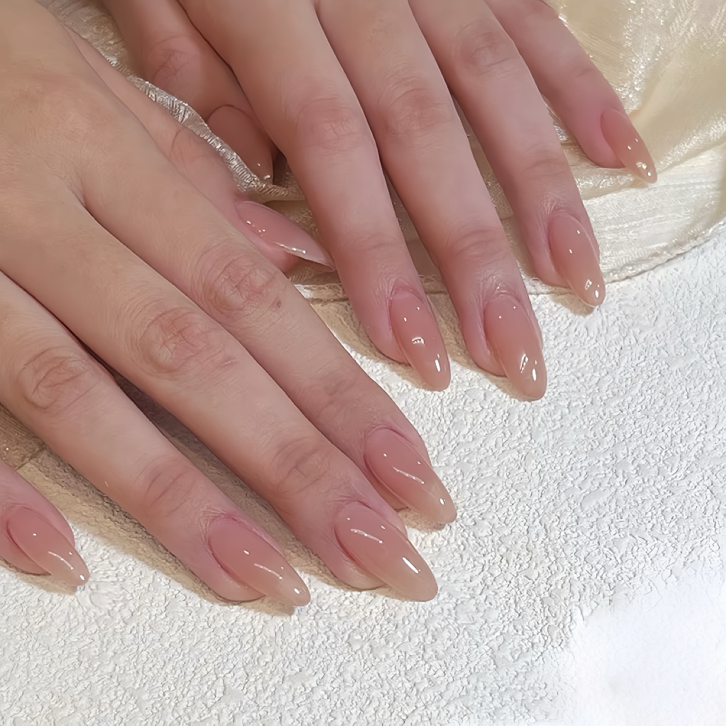 Close-up of hands with nude nail polish on a textured white background