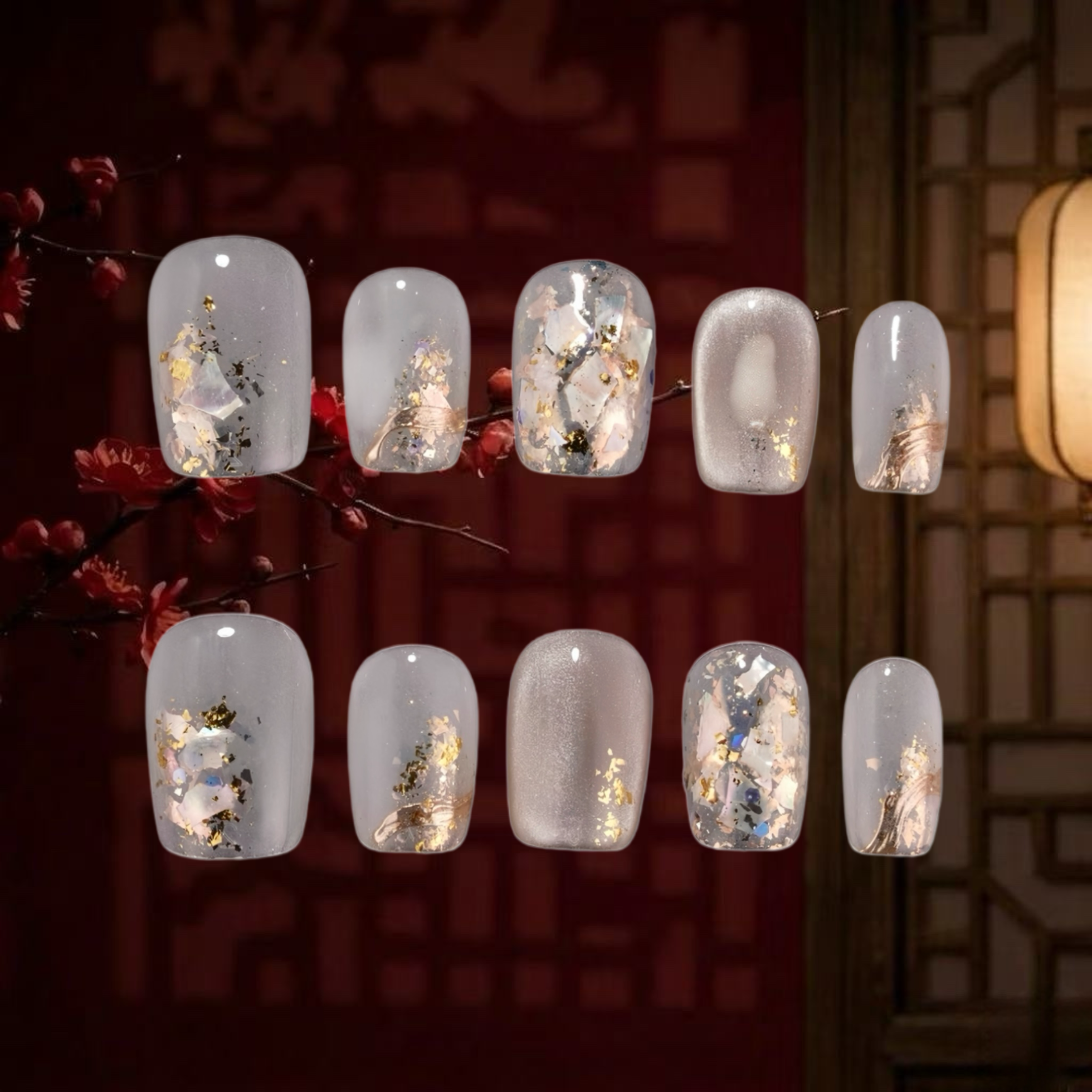 Nail art display with decorative designs on clear nail polish against a warm-toned background.