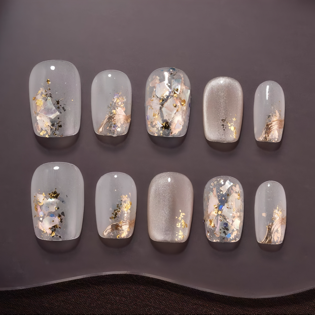 Set of decorative nail art with glitter and small embellishments on a dark background
