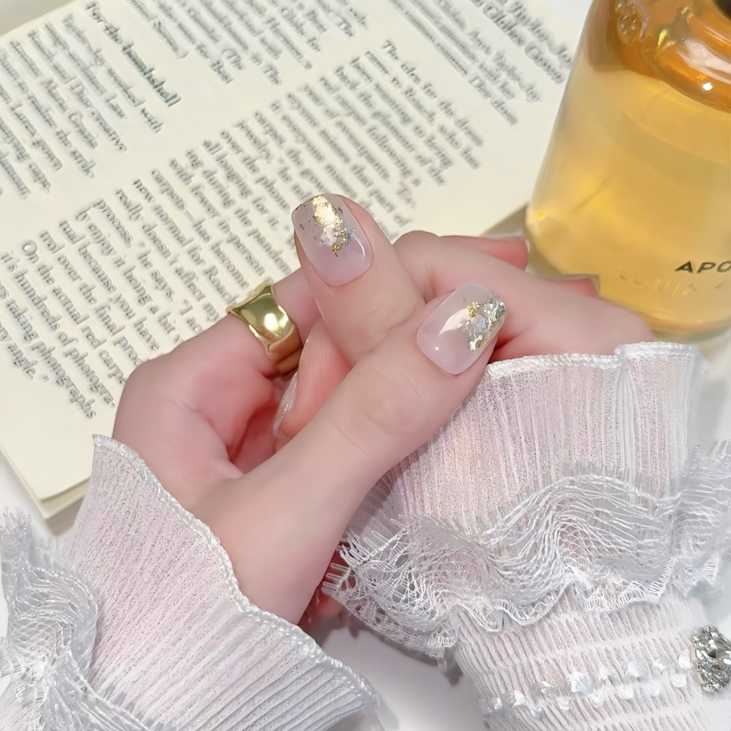 Close-up of hands with pink nail polish and a gold ring, holding a bottle labeled 'Apotheke'.