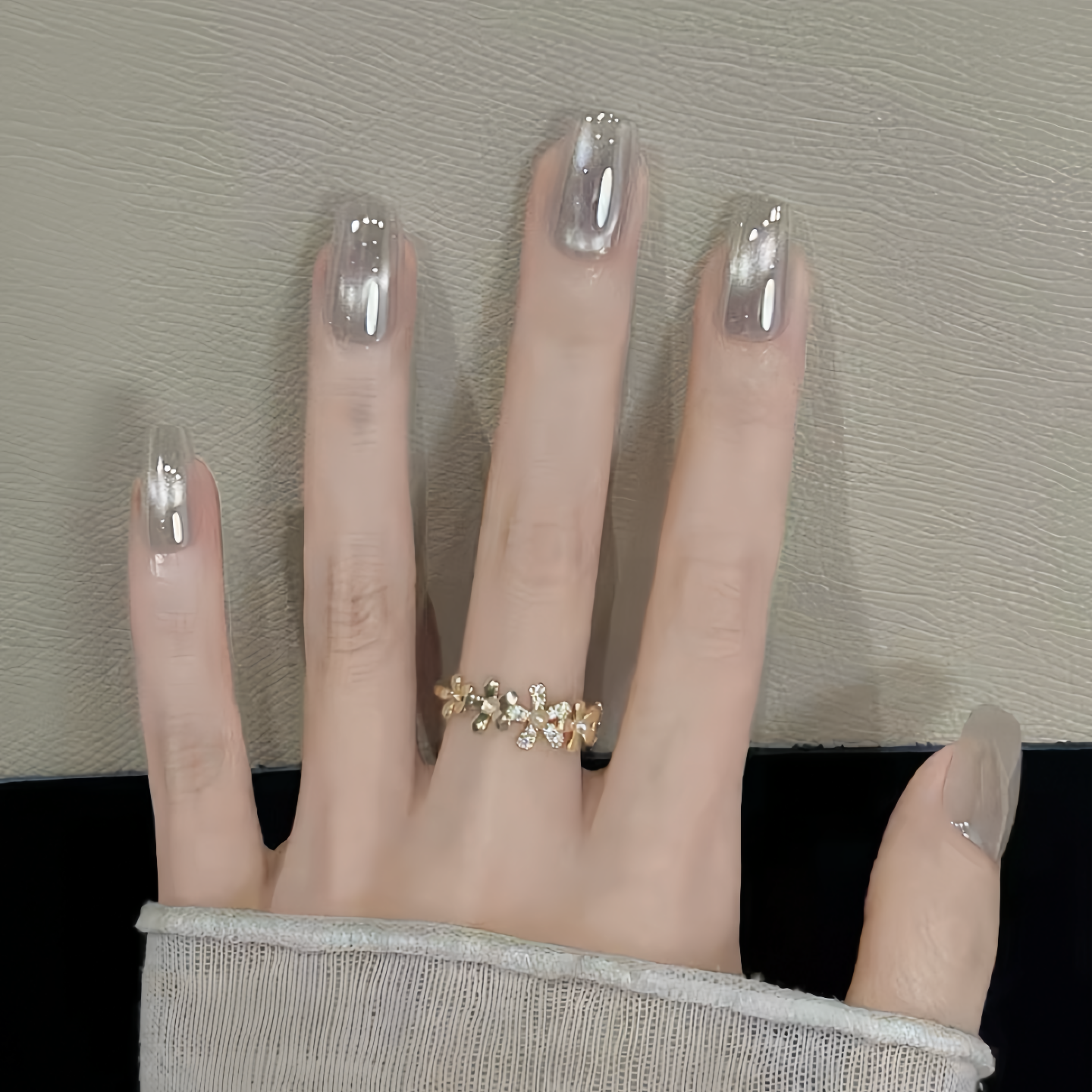 Hand with a gold ring on a neutral background